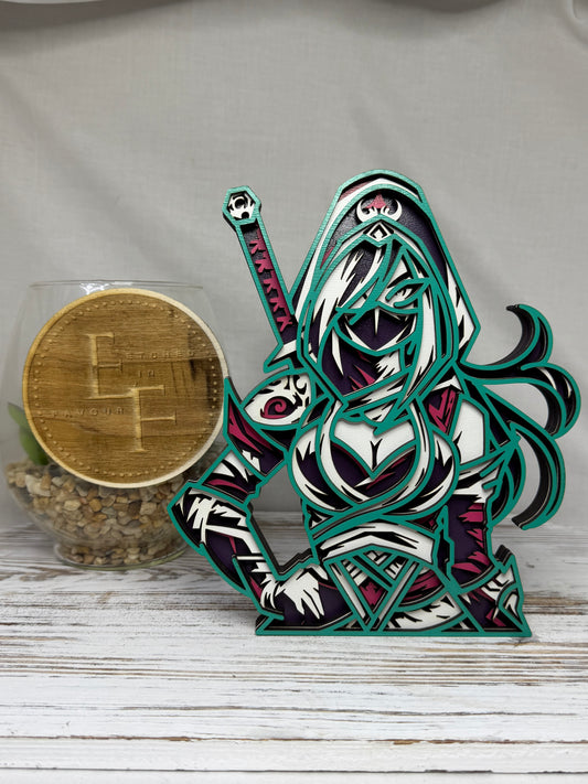 A laser cut multi-layered Ninja word decor of a hooded female warrior holding a sword, colored in teal, purple, white, and pink. 