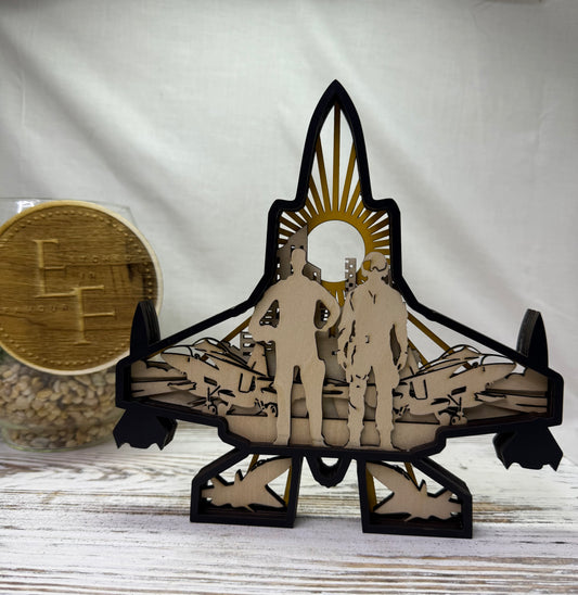 A multilayer laser-cut wooden decor piece featuring a fighter jet silhouette with two soldiers standing inside, set against a sunburst motif from Etched in Favour.